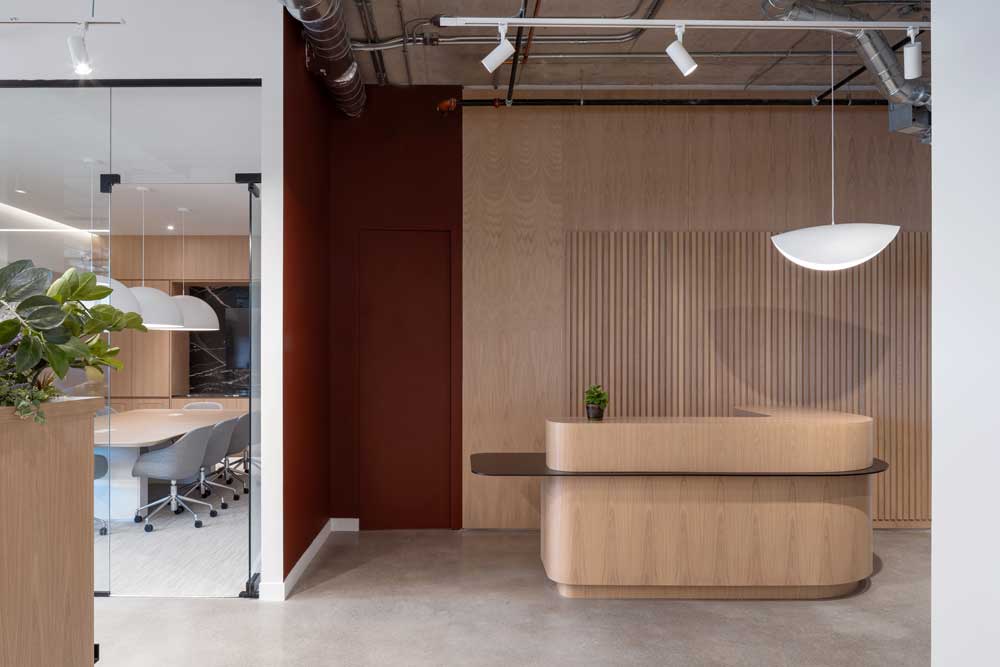 Front desk and reception area mainly in wood finish and a burgundy accent wall