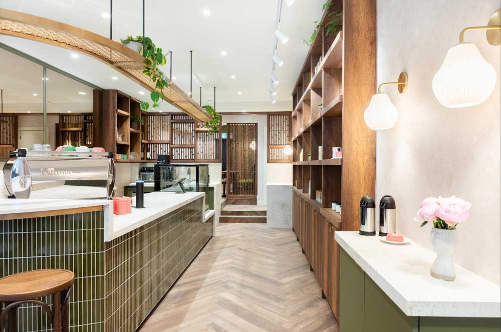 View of the cafe from the entrance, greenery and live plants, green and wooden finishes all reminiscent of nature