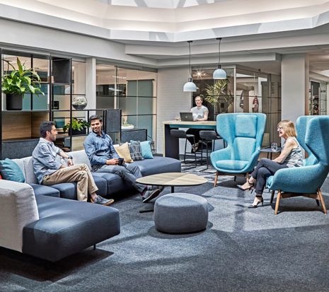 One of the main gathering hubs provides natural light from skylights, lush plants, and adjoined rooms which bridge indoors and outdoors.