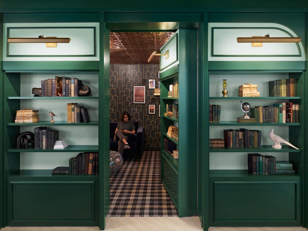 A quiet hidden speak easy behind a hidden shelf door in a dark green colour
