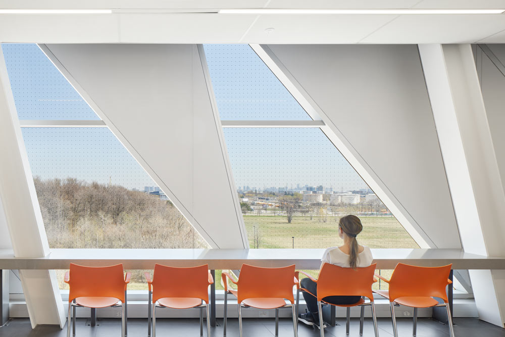 Seating along the geometric shaped window openings provide a view of the outdoors