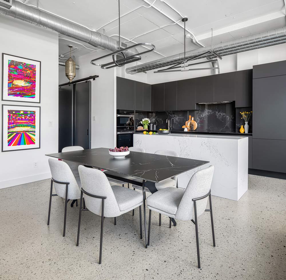 A view of the neutral coloured dining and kitchen area with bright pink artwork on the wall to the left