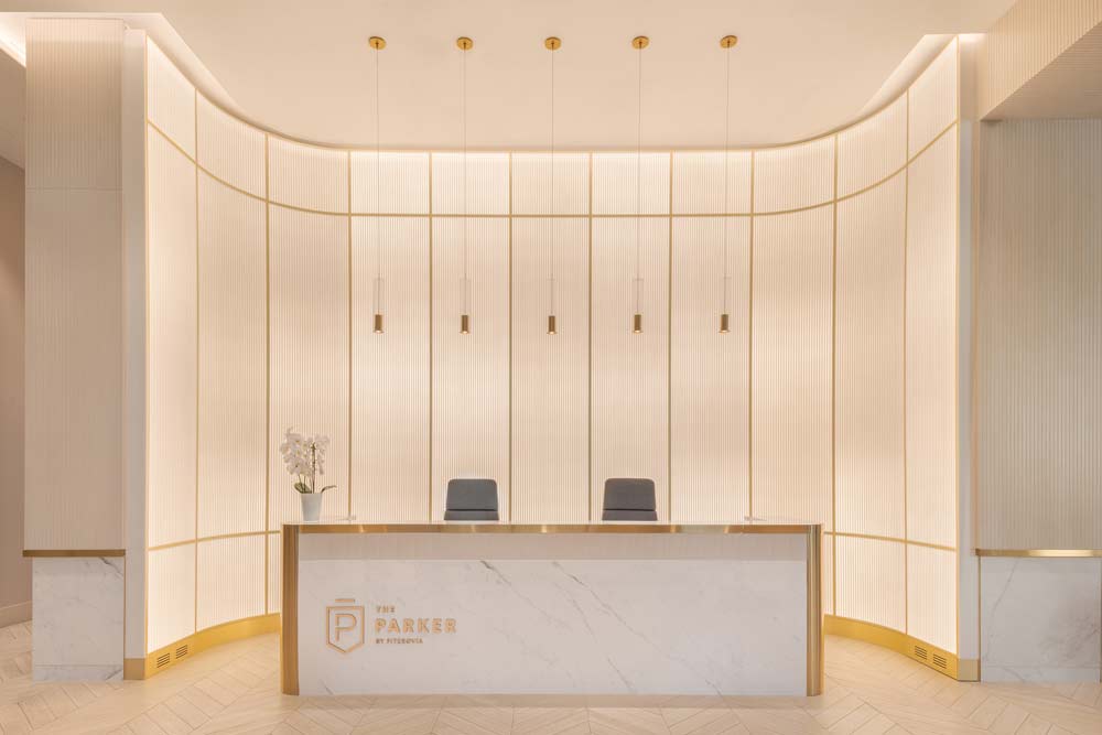 Infused with cool Nordic design elements, the lobby features a stunning frosted glass wall and silvery blond woods that emphasize the dramatic verticality of the space. The textured glass behind the reception desk is back lit for a diffused, icy glow