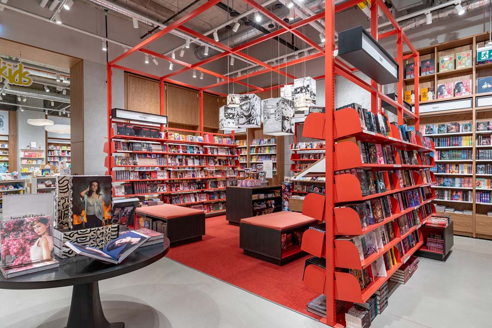 A striking pop of red shelving and hanging pendant lights featuring Manga illustrations in the manga & graphic novel shop