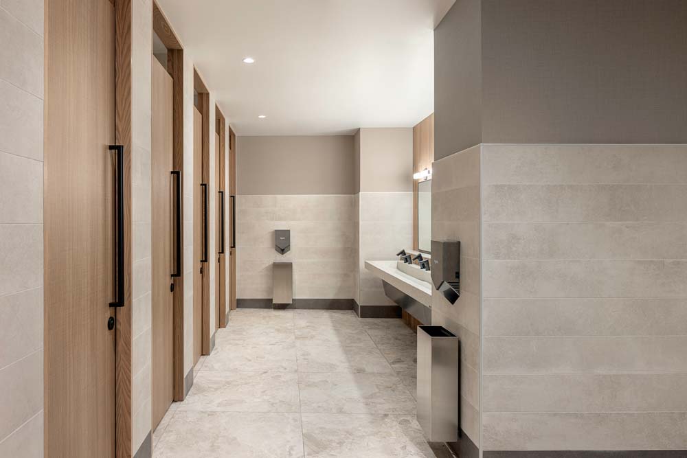 Toilet stall doors are on the left and accros from them on the right is the barrier free sink area. 